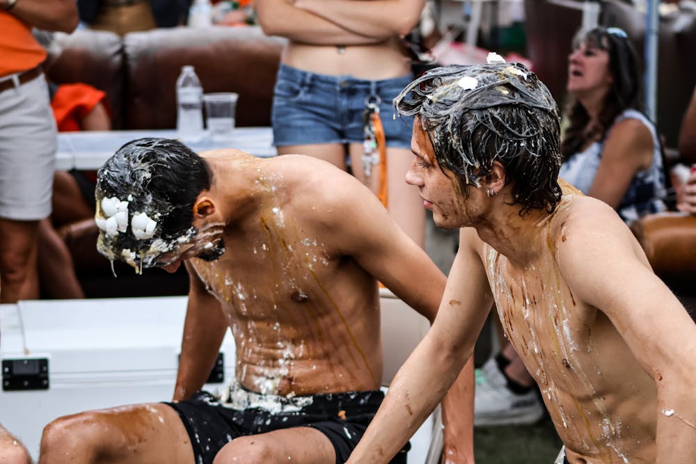 Two Mercer students affiliated with Phi Delta Theta, Michael Gonzalez '27 (left) and Tristen Lowell '29 (right), participate in a "Pie a Phi" fundraising event on Oct. 4, 2025. The event attracted many families to the fraternity's tent on Black Field to watch the students get doused with syrup, whipped cream and eggs.