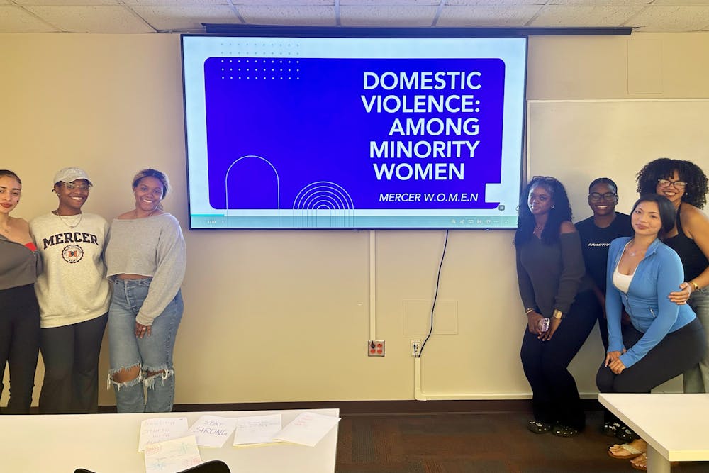 <p>The executive team for Mercer W.O.M.E.N. poses in front of the domestic violence presentation on Oct. 15.</p>