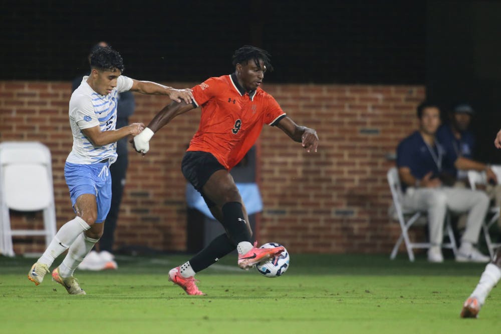 <p>Barzee Blama &#x27;27 fends off a University of North Carolina defender. Photo courtesy of Willis Glassgow.</p>