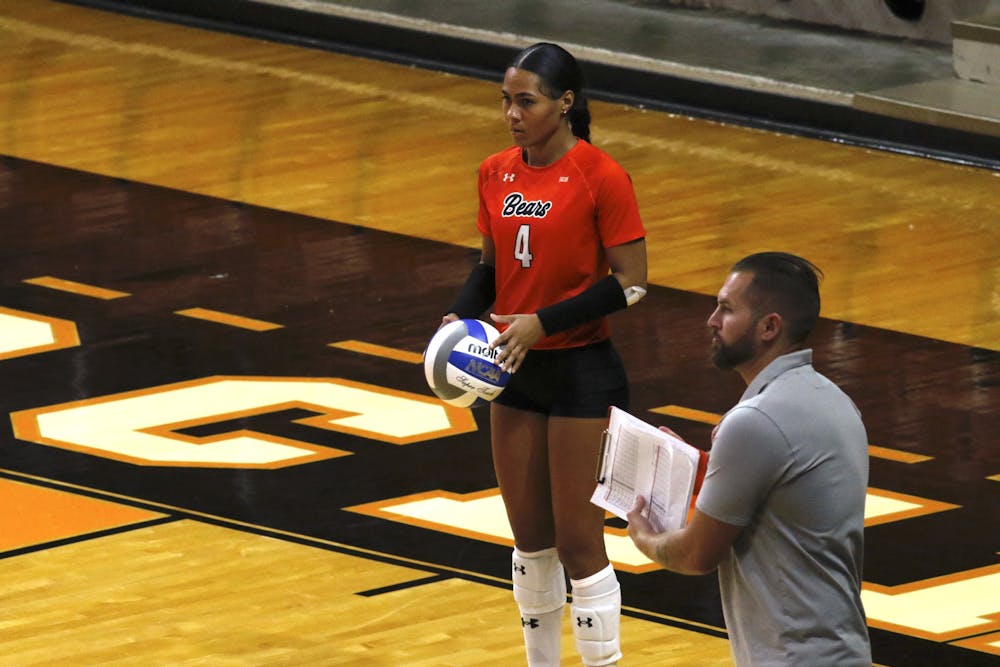 MeMe Davis '28 prepares to serve against East Tennessee State University as second-year Head Coach Chad Sutton looks on.