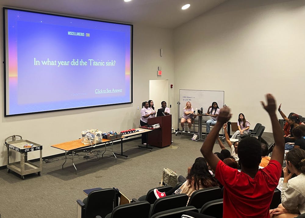 Hands shot into the air as students tried to steal points from other teams at Jeopardy, hosted by Quadworks on Sept. 12.