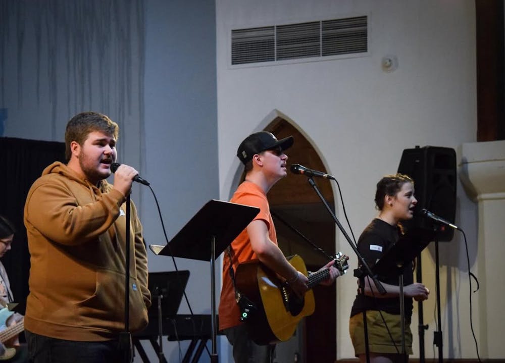 Jesse Tyre '28 (left), Nolan Newberry '26 (middle) and Kate Van Meter '26 (right) sing on stage at Newton Chapel during BCM. Photo courtesy of Rachel George.