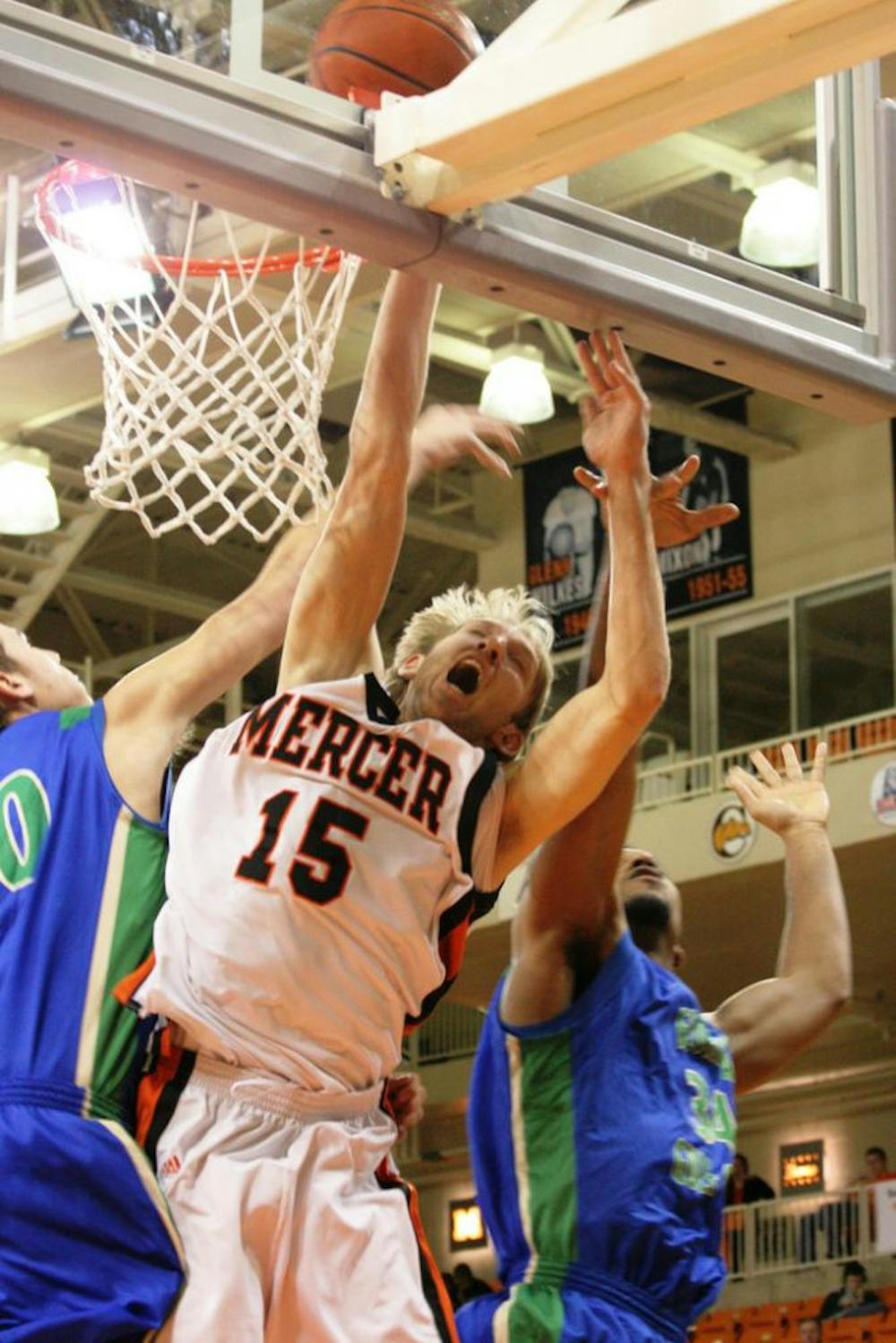 (Alex Lockwood / Cluster Staff) Mercer's Justin Cecil attempts to dunk between two Florida Gulf Coast defenders in a recent home win against the Eagles.