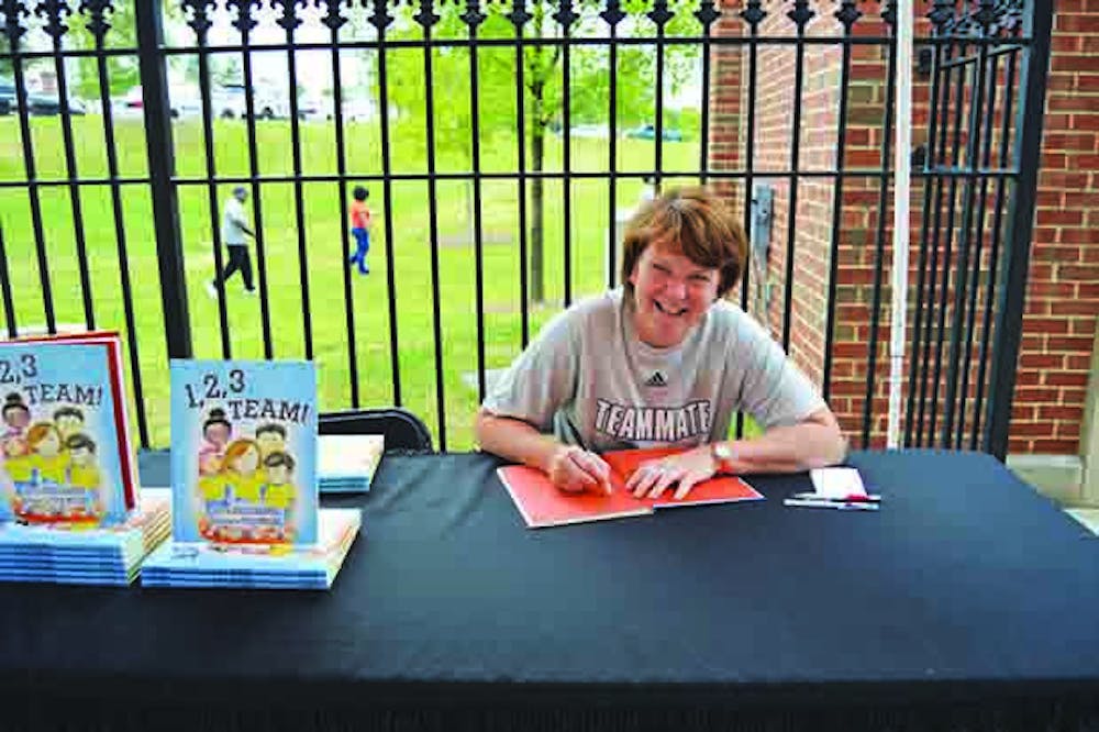 Coach Gardner signing copies of her children's book '1,2,3 Team" at the Mercer vs. Citadel football game on September 1.
