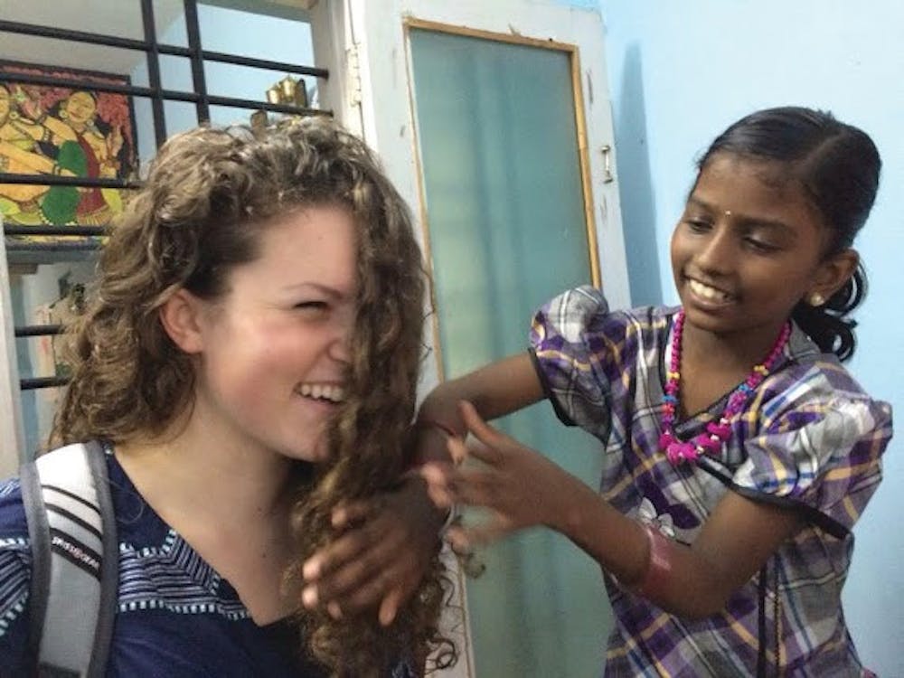 Young girl from India plays with Mary Lathem’s hair during her Mercer on a Mission trip to India