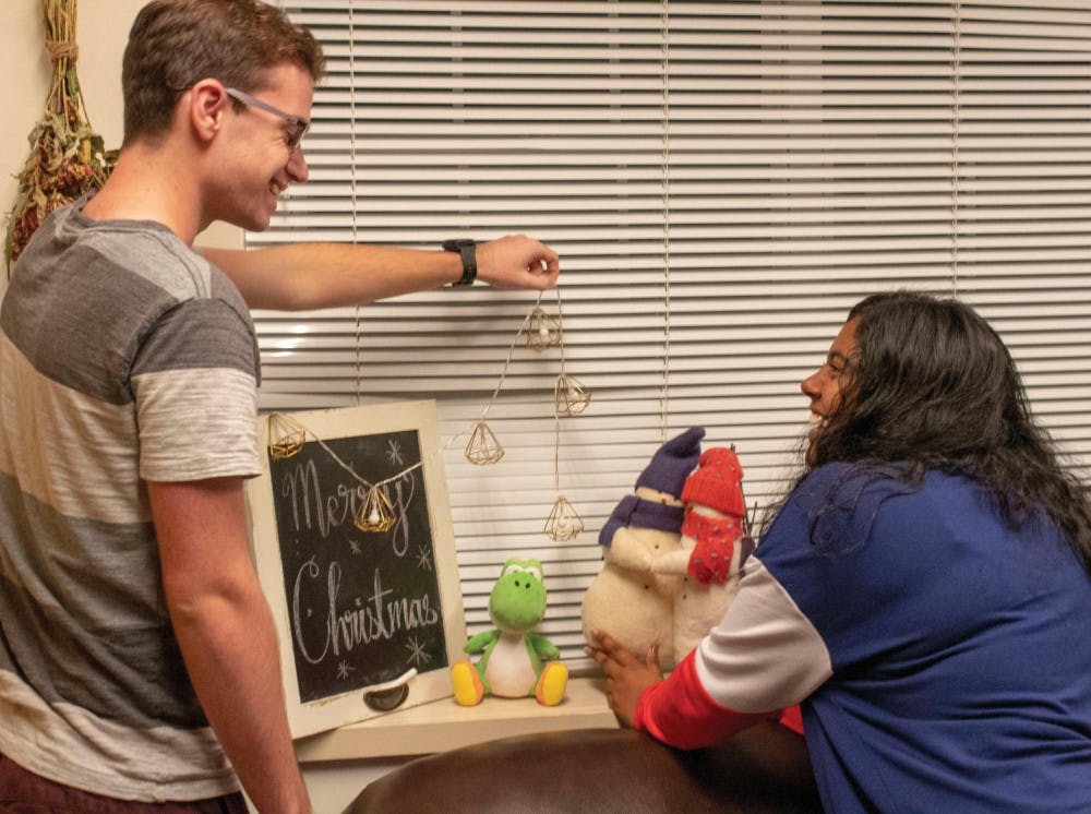 Second-year students Leo Peace and Pooja Vikraman decorate for the holiday season.