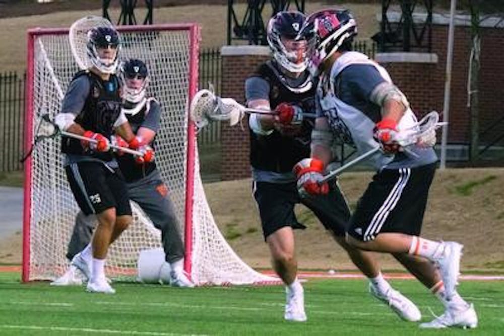 Midfielder Jackson Teague attempts a run on the goal at practice, defended by midfielder Rob Serafin.