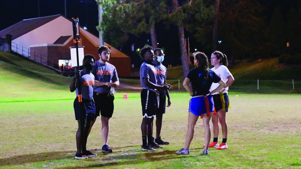 A group of referees speaks with the two teams participating in the Women's Flag Football championship game Oct. 22. 