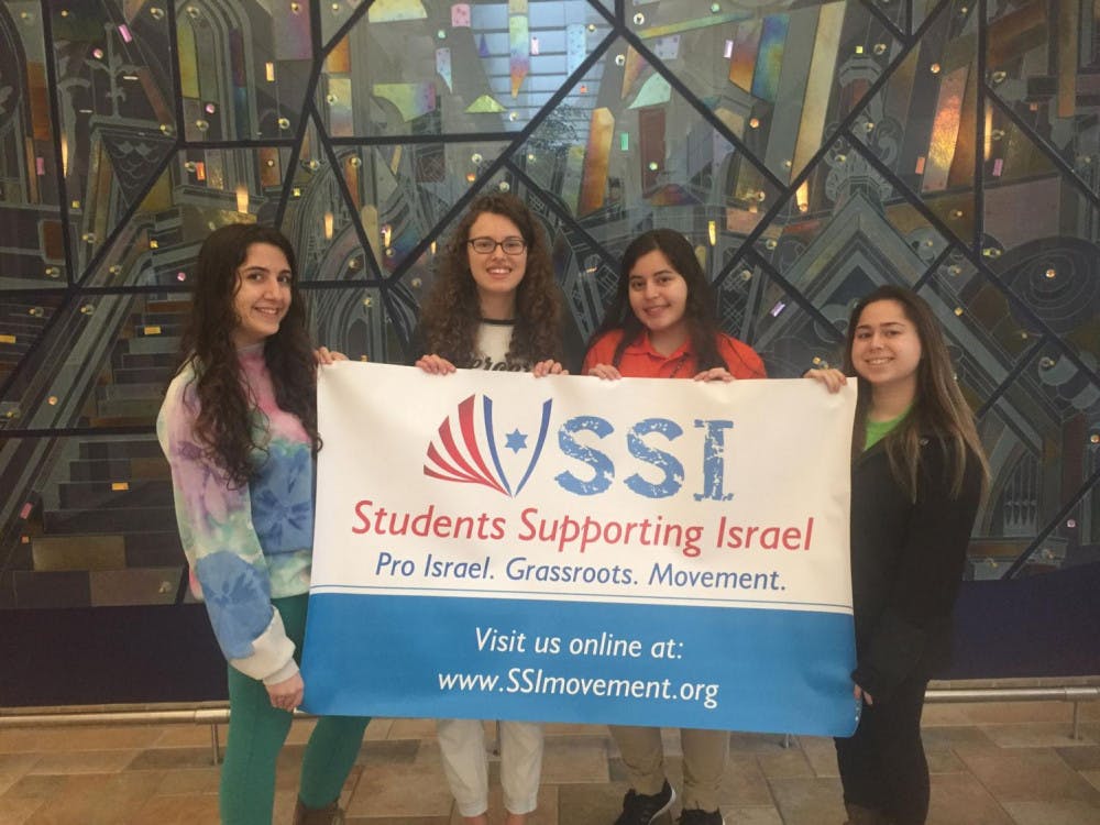 Officers of the new Students Supporting Israel, Chloe Phillips, Shanna Mattson, Maria Ilyayeva and Jenna Bruck (from left to right) stand with a banner of the club’s logo.