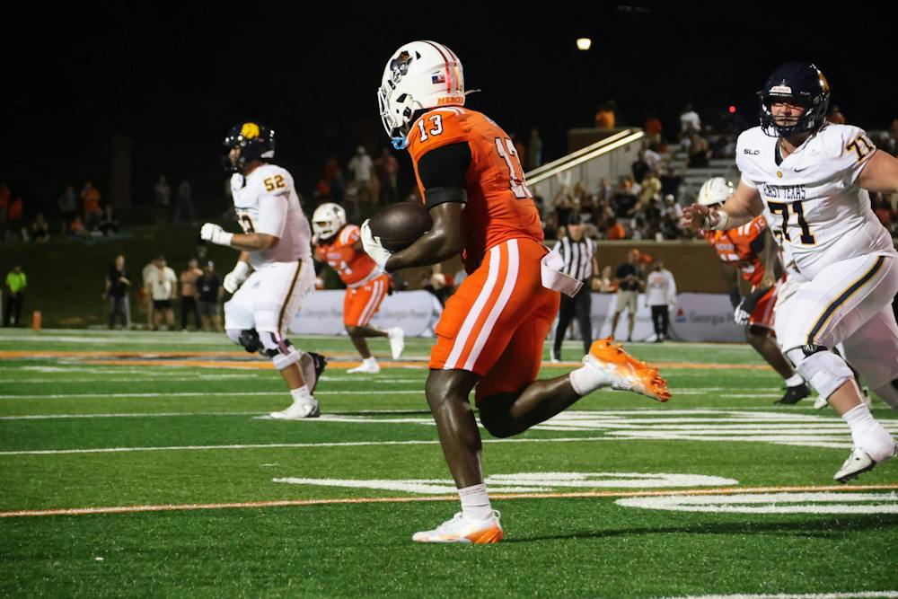Braylon Stewart '29 runs past an defensive lineman in a game against East Texas University on Aug. 29.