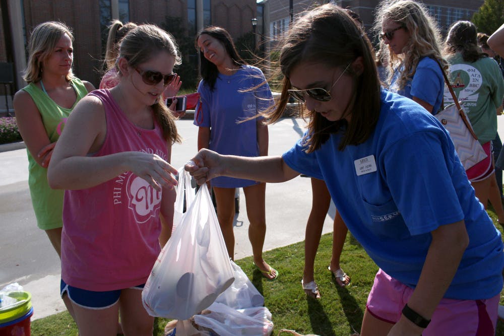 Abby Jacobs, a member of MerServe, and Abby Hundley, a member of Phi Mu, sort through over 100 cans of food that Phi Mu donated to participate in Water Wars, an event held by MerServe. Phi Mu had around five teams enter the competition to play a game of dodgeball with water balloons.
