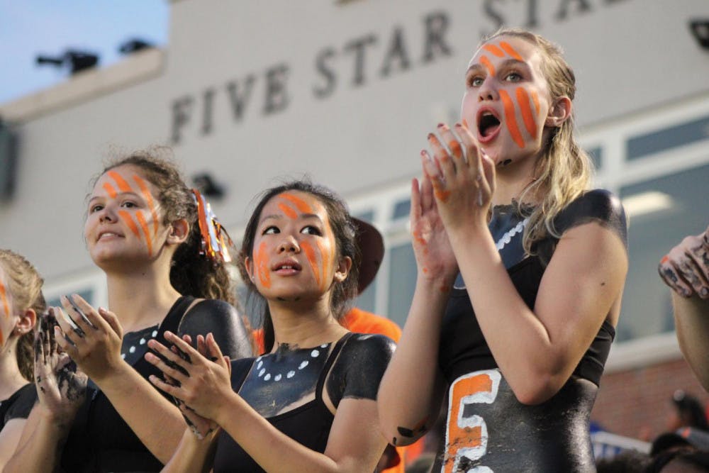 Emma McDaniel (left), Naomi Fan (middle) and Kristin Ware (right)
cheer on the Mercer Bears during their first home game.