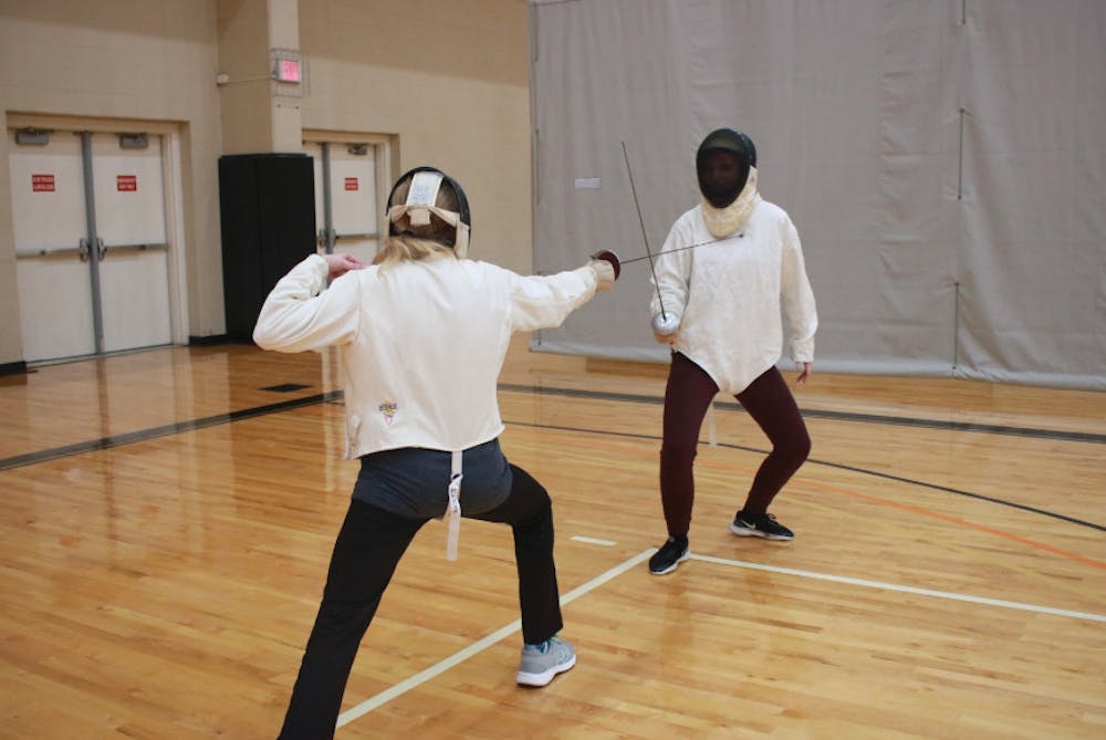 Cecelia Poehlman (left) and Mo Baldwin (right) practice with foil swords.