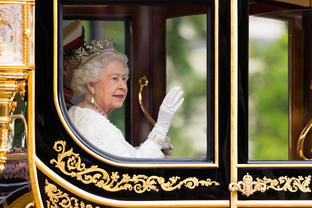 Her Majesty The Queen waves out of the brand new Britannia State Coach for the first time on June 4, 2014. She is attending her 61st State Opening of Parliament as Monarch. (Michael Garnett, licensed under CC BY-NC-SA 2.0)
