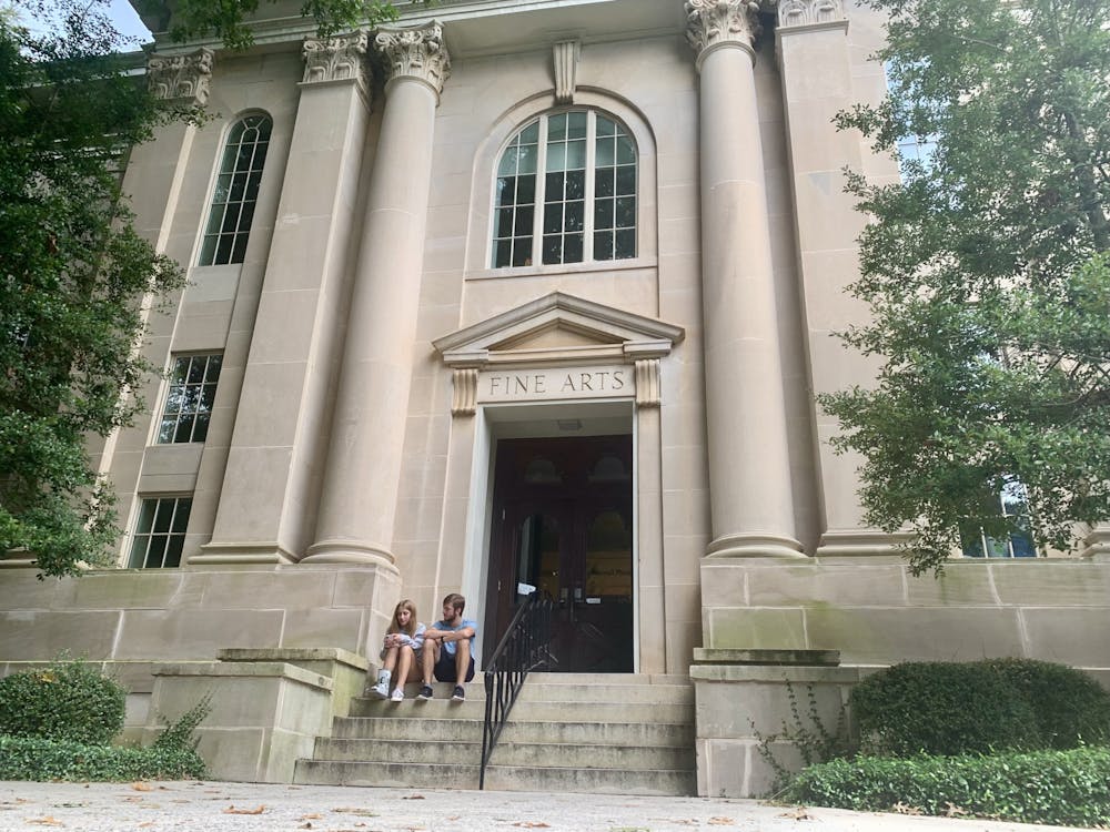 <p>Students sit in front of Hardman Hall, home to the Mercer Department of Art.</p>