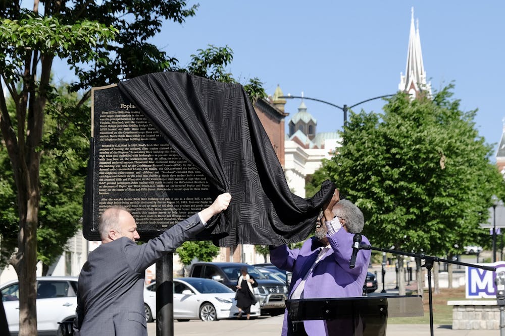Macon-Bibb County Mayor Lester Miller and Macon200 Co-Chair Alex Habersham unveil one of three markers displaying information about Macon's Black history at an opening ceremony on Poplar Street Monday. 