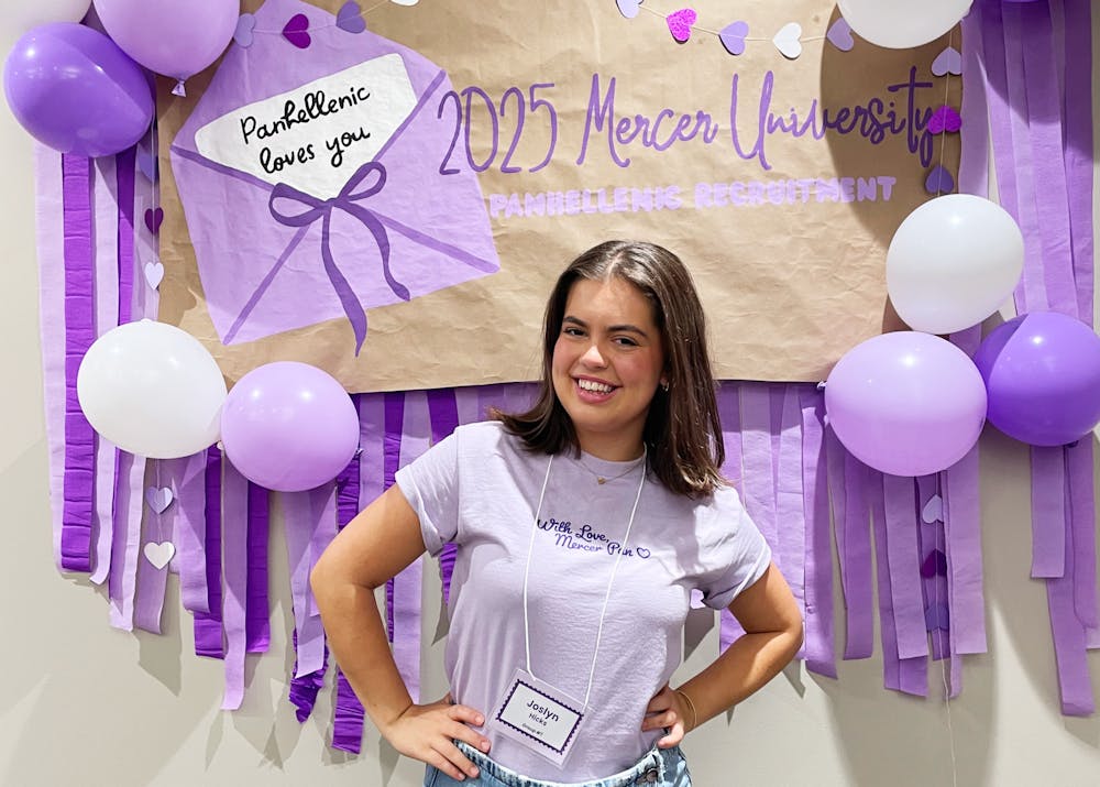 Joslyn Hicks '29 stands in front of a poster on opening night of Panhellenic recruitment.