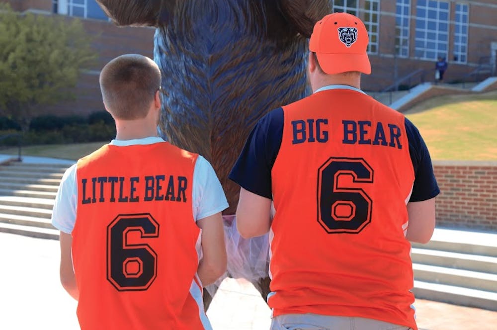 Braeden Lee Brettin carried by Seth James Thompson while wearing their "little" and "big" bear jerseys.