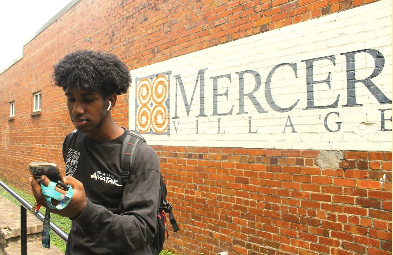Michael Williams '23, a communications and media studies major, chooses his next song on his way to class.