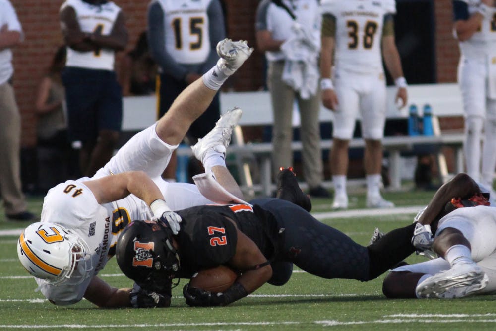 Mercer Bears' Alex Lakes (27) is tackled by Chattanooga's Marshall Cooper (40) in their game on Saturday, October 14 in Mercer's stadium.