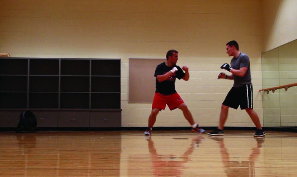 Will Darragh and James Smith spar during Mercer’s Krav Maga group fitness class.