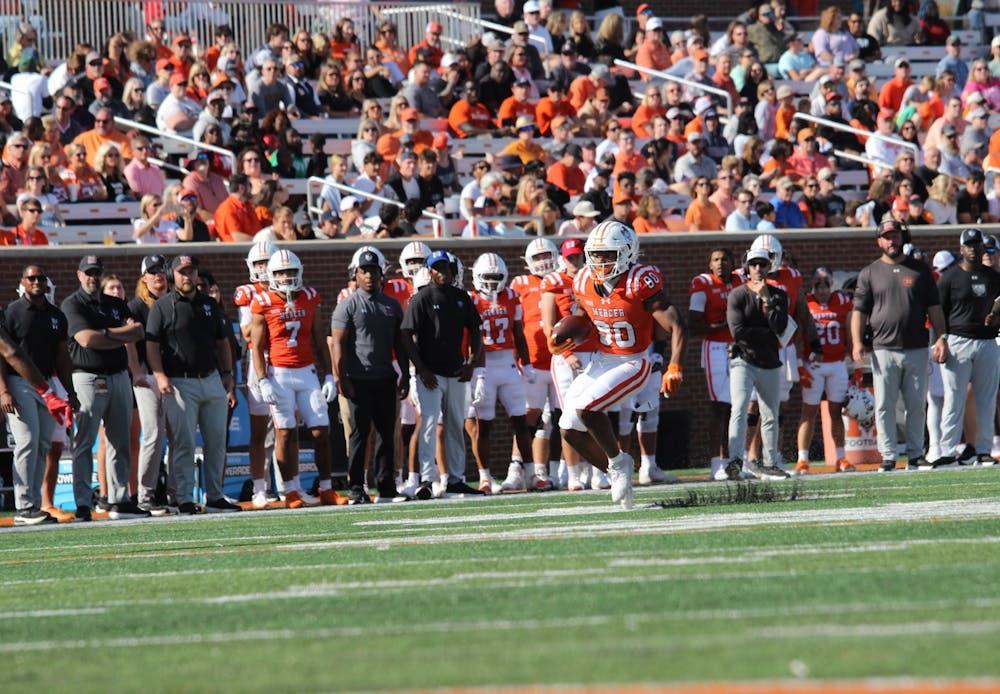The crowd at Five Star Stadium looks on as running back Ty Doughty '29 stutter steps against Virginia Military Institute on Oct. 25.