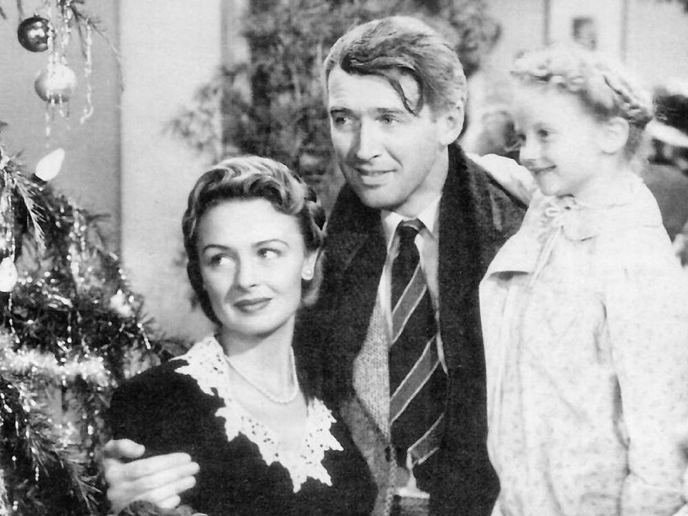 Screenshot of Jimmy Stewart, Donna Reed, and Karolyn Grimes in the American film It's a Wonderful Life (1946).
