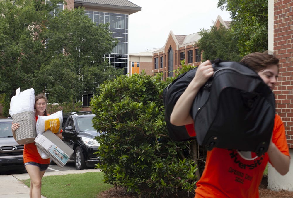 <p>Peer Advisors and Mercer Movers Samantha Shadoff ‘25 and Kevin White ‘25 carry luggage into Plunkett Hall on Friday, August 19, 2022, to assist first-year students moving into campus residence halls for the first time.</p>