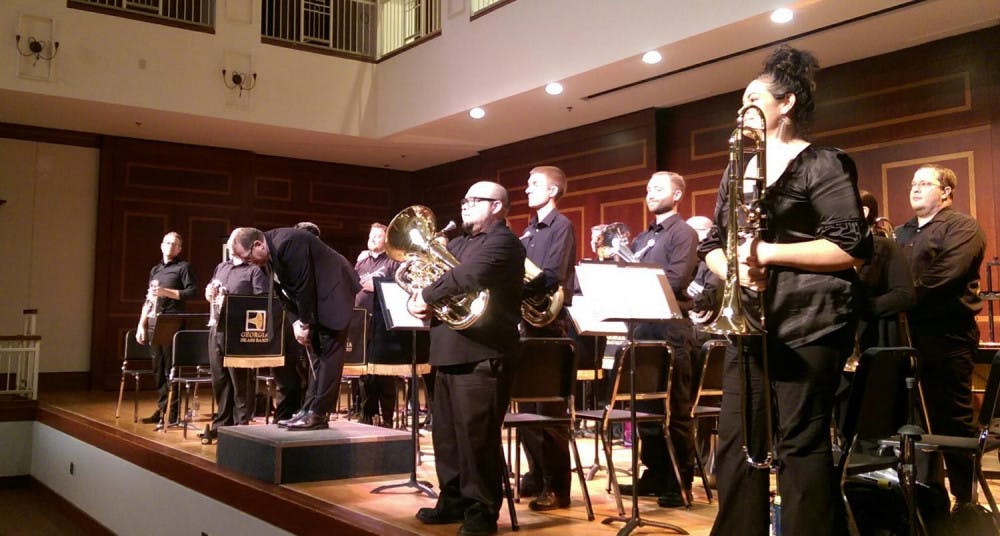 Georgia Brass Band director Joe Johnson takes a bow as band members stand for a roaring applause at intermission.