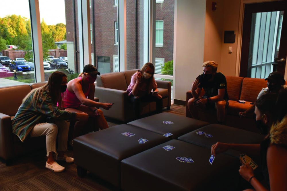 Friends play a card game in the freshman dorm Legacy Hall.