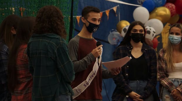 The Colleges Against Cancer executive board joins a survivor for his speech at Relay for Life on Oct. 23 in the Recreation Center (Izzy Smith / Photographer).