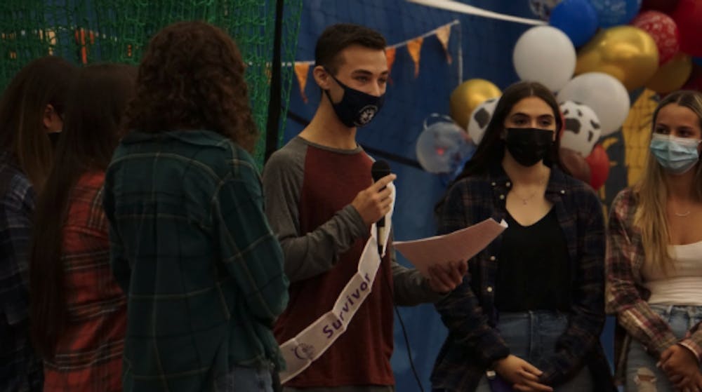 <p><em>The Colleges Against Cancer executive board joins a survivor for his speech at Relay for Life on Oct. 23 in the Recreation Center (Izzy Smith / Photographer).</em></p>