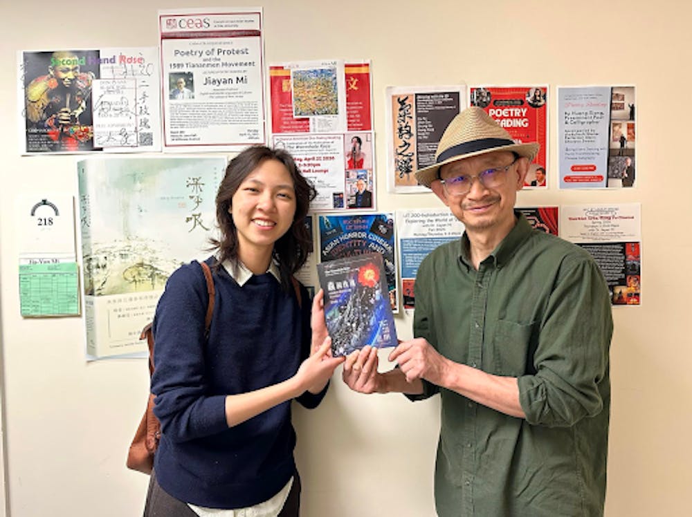 <p><em>Jiayan Mi and Vanessa Y. Niu with Mi’s new poetry book “The Wormhole Rose.” (Photo courtesy of Jiayan Mi)</em></p>