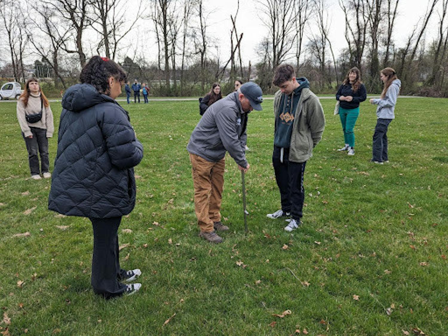 TCNJ Organic Land Management students are taught by Richard McCoy, principal owner of Richard A. McCoy Horticultural Services Inc., to take soil samples off the ground at the pilot location (Photo courtesy of Jenna Needham and Maria Hourihan).
