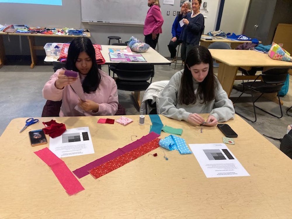 <p><em>Stephanie Sookram (left), a freshman accounting major, and Alyssa Faer (right), a freshman elementary education major, make a patch for the second climate quilt during a workshop in AIMM 102 on Feb. 25. (Photo by Franc Romanowski)</em></p>