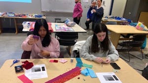 Stephanie Sookram (left), a freshman accounting major, and Alyssa Faer (right), a freshman elementary education major, make a patch for the second climate quilt during a workshop in AIMM 102 on Feb. 25. (Photo by Franc Romanowski)