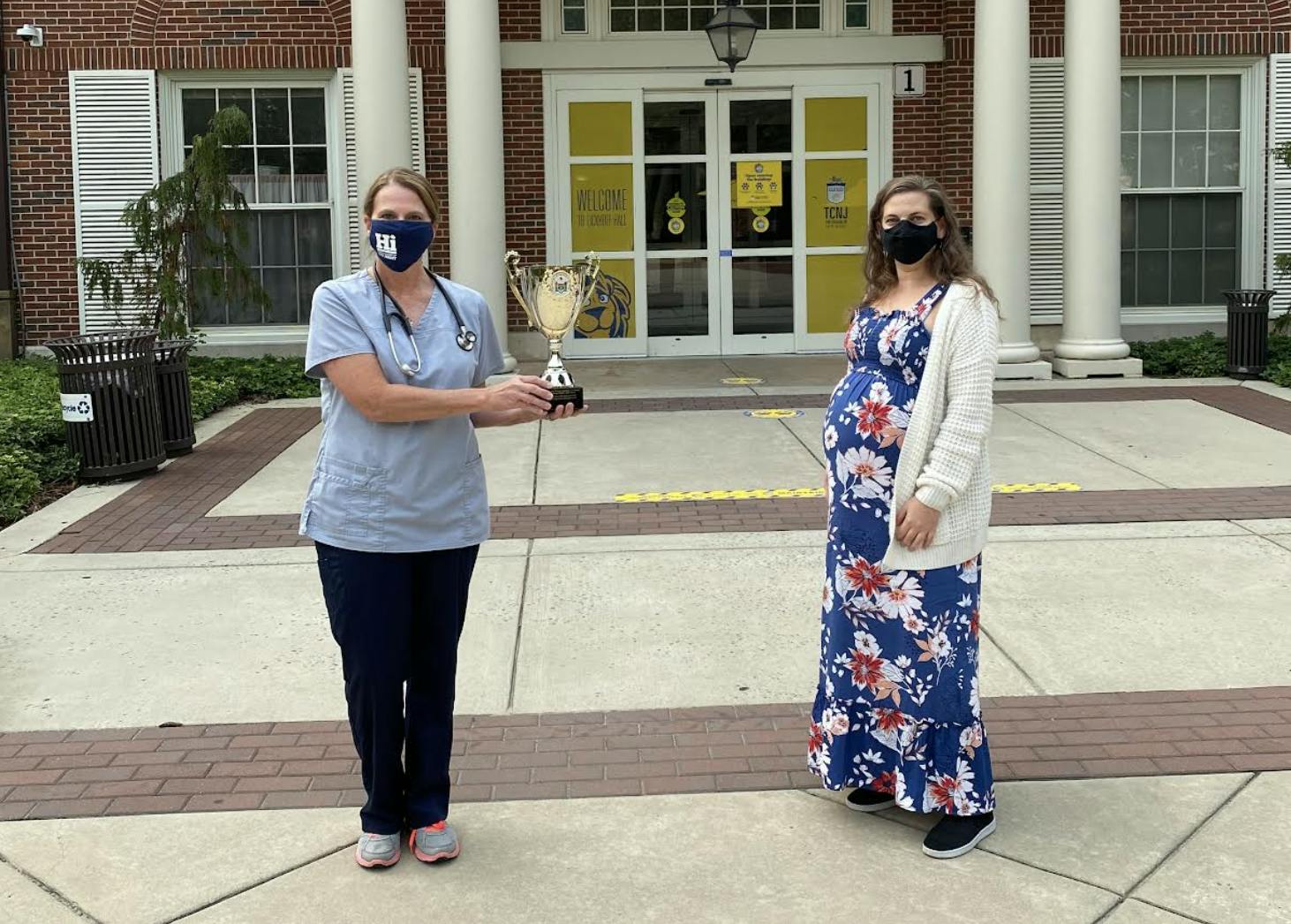 Adult Nurse Practitioner Barbara Clark (left) holds the College’s trophy awarded for placing first in the 2020 New Jersey College and University Flu Challenge next to Erika Lobe (right), Adolescent/Adult Immunization Coordinator in the Vaccine Preventable Disease Program with the New Jersey Department of Health (Photo courtesy of Barbara Clark).
