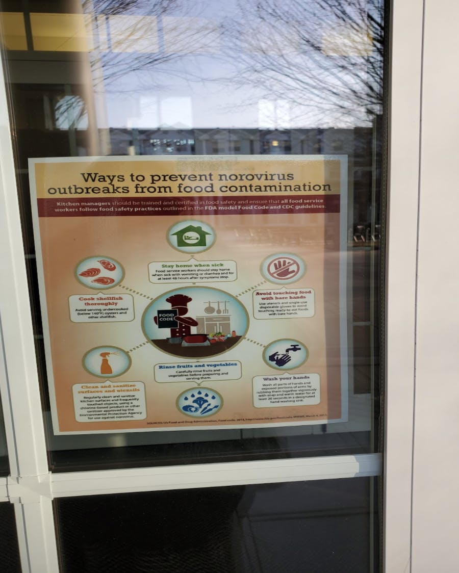 Signs are hung on the library doors regarding how to prevent getting norovirus from food (Photo Courtesy of Catherine Gonzalez / Staff Writer). 