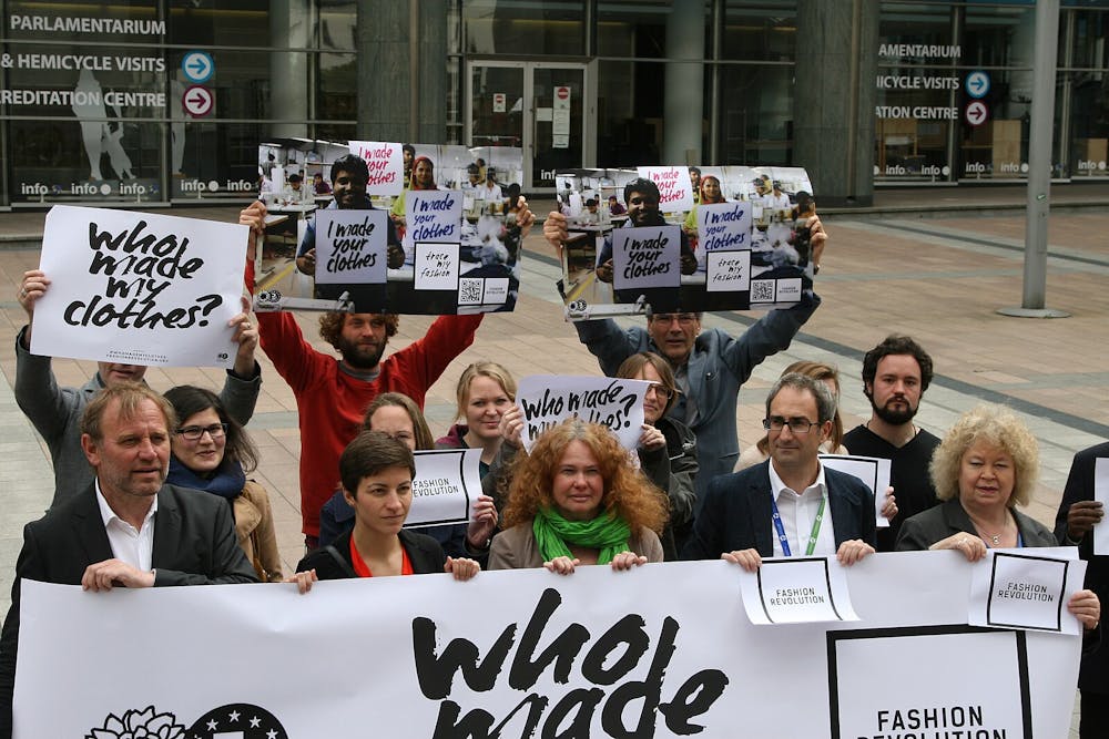 <p><em>Fast fashion promotes a culture of greed and labor exploitation. (Photo courtesy of </em><a href="https://commons.wikimedia.org/wiki/File:Who_Made_My_Clothes_Protest.jpg" target=""><em>Wikimedia Commons</em></a><em> / greensefa, April 22, 2015)</em></p>