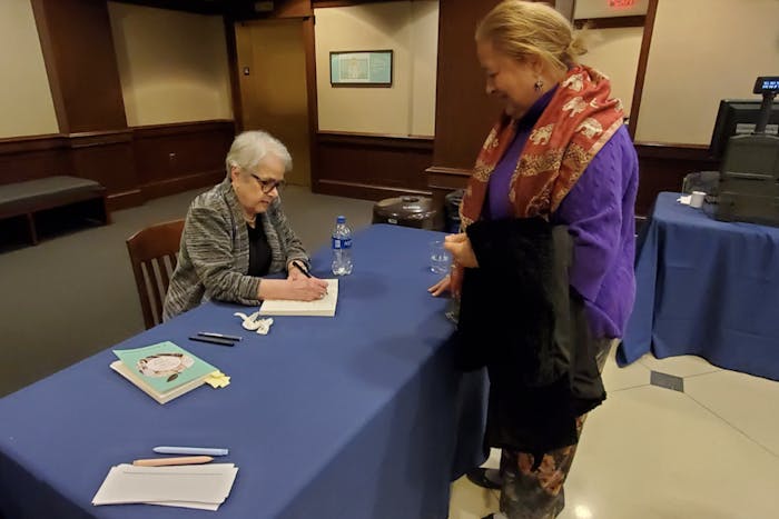 R. Barbara Gitenstein signing book of TCNJ alumnae Carole Bridges (Photo courtesy of Catherine Gonzalez / Correspondent). 