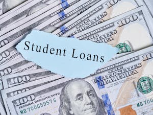 On Tuesday, the Supreme Court held a hearing on President Joe Biden’s student loan forgiveness plan that would cancel up to $20,000 in student debt for borrowers with limited earnings (Photo courtesy of Flickr/“Text - Student loans on paper piece with a pile us dollar bills” by Marco Verch Professional Photographer. May, 25, 2021).