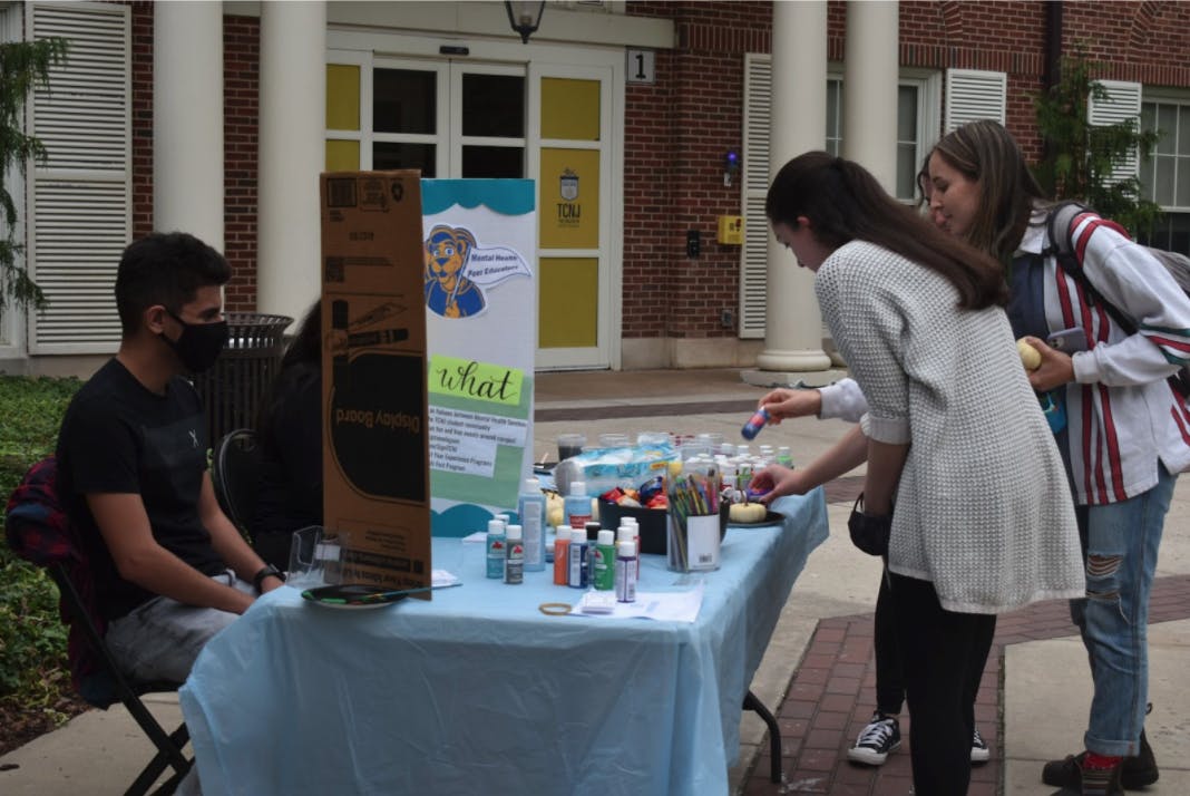 Students in Alumni Grove on Oct. 13 participate in Mental Health Services’ “Scare Your Stress Away” pumpkin painting event (Liz Osekavage / Photo Editor).