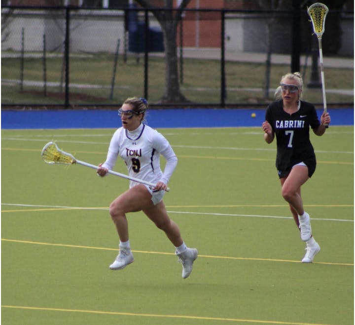 (M/D Wayden Ay floats by defender on her way to 4 points and 7 ground balls. Photo courtesy of Joey Bachich).