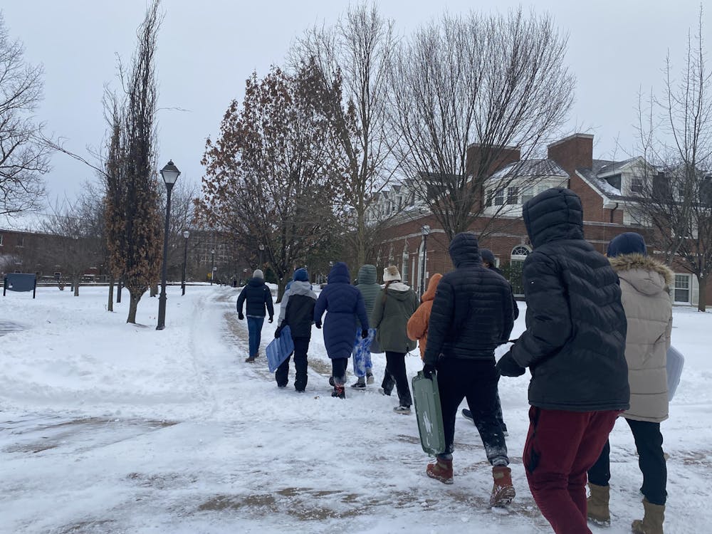 <p><em>Students are seen walking through the snow after a storm swept through the College (Karla Fonseca / Staff Writer). </em></p>