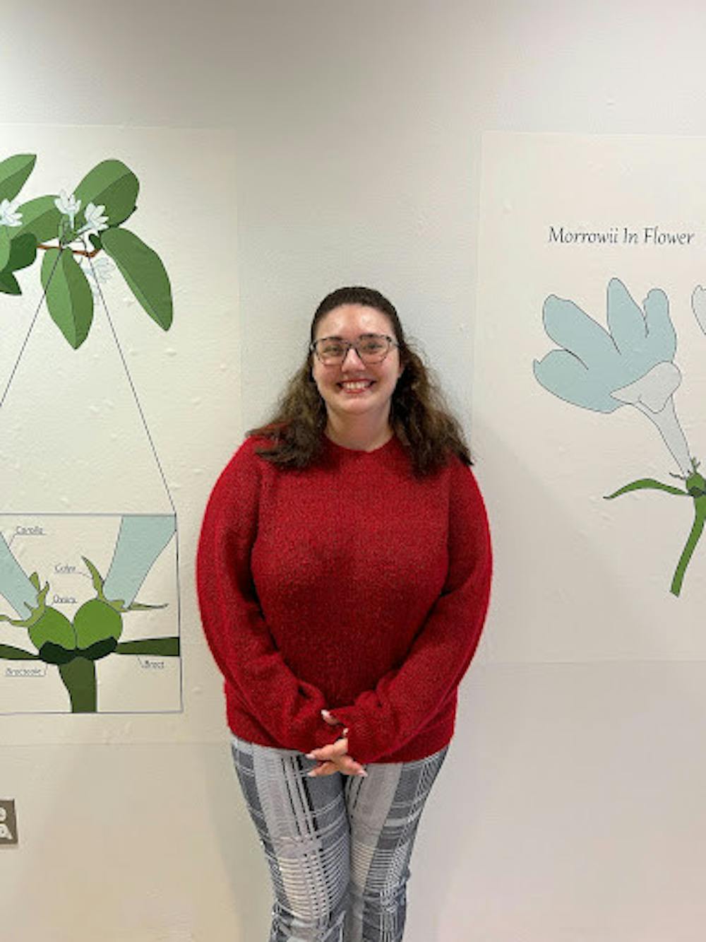 <p><em>Leann Janzekovich standing in front of a Lonicera Morrowii honeysuckle diagram. (Photo Courtesy of Jasmine Lee / Staff Writer) </em></p>
