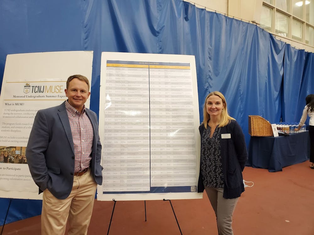 MUSE directors Tracy Kress, a biology professor, and 
John Leonard, a music professor, posing in front of a 
list of MUSE presentations (Photo courtesy of Rachel Lea / Contributor).