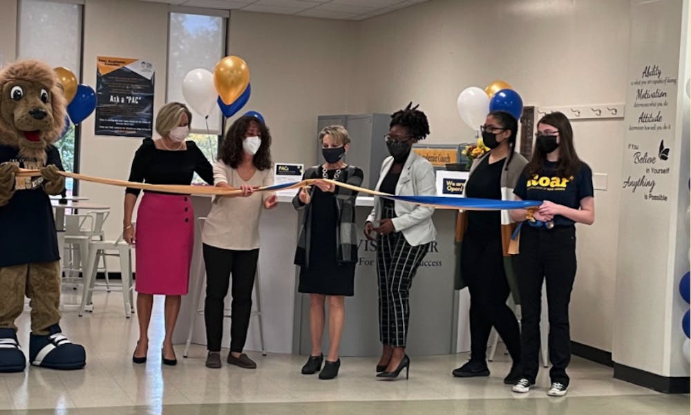 <p><em>President Foster cuts the ribbon for the Center for Student Success’s new Advising Bar in Roscoe West Hall on Oct. 27 (Emma Ferschweiler / Staff Writer).</em></p>