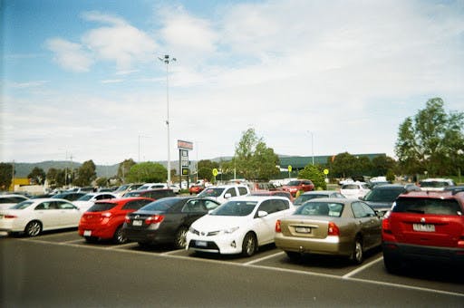 Commuters often need to devote extra time to driving and finding a parking space. (Photo courtesy of Flickr / “2018 Parking Lot” by Matthew Paul Argall / October 30, 2018).