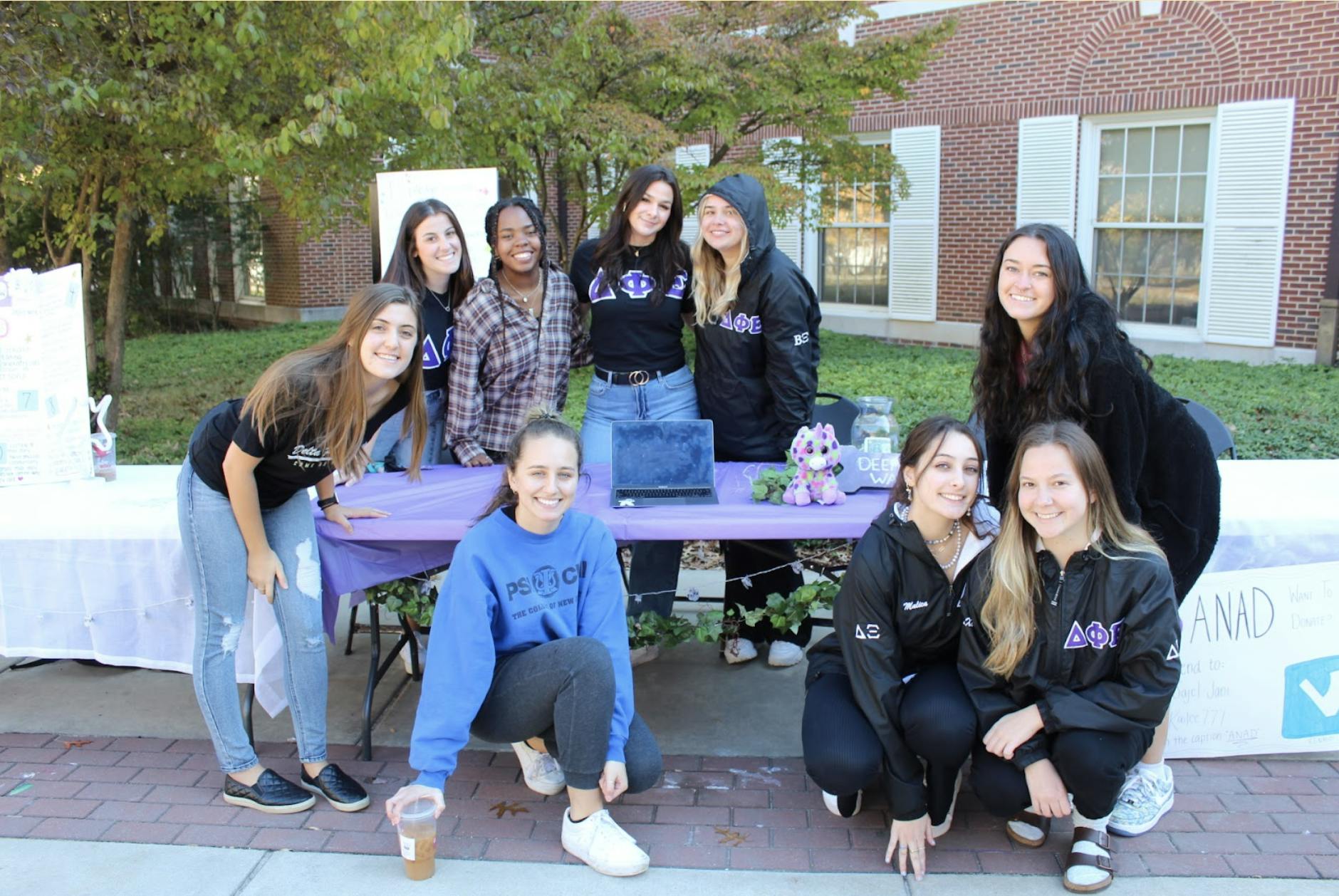 Members of Delta Phi Epsilon pose for their tabling event outside of Eickhoff Hall during ANAD week (Elizabeth Gladstone / Photographer).