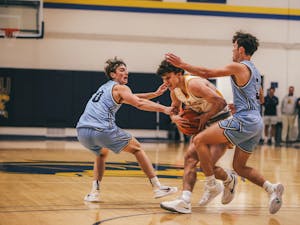 Nick Koch controlling the ball between two defenders (Photo courtesy of Arion Owes).